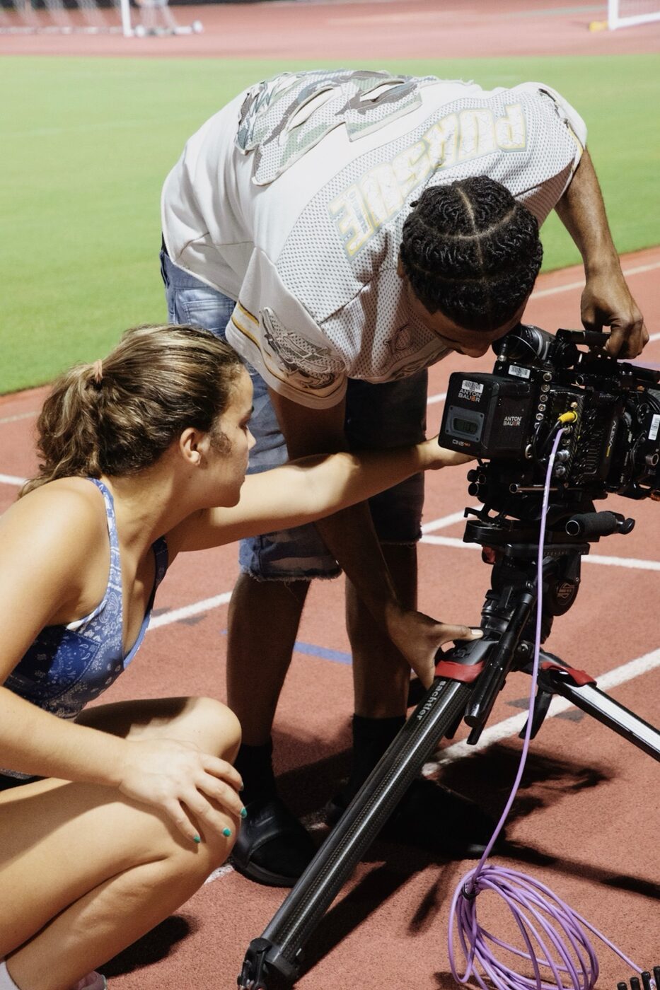 Maya filming an athlete on a cinema rig at a track